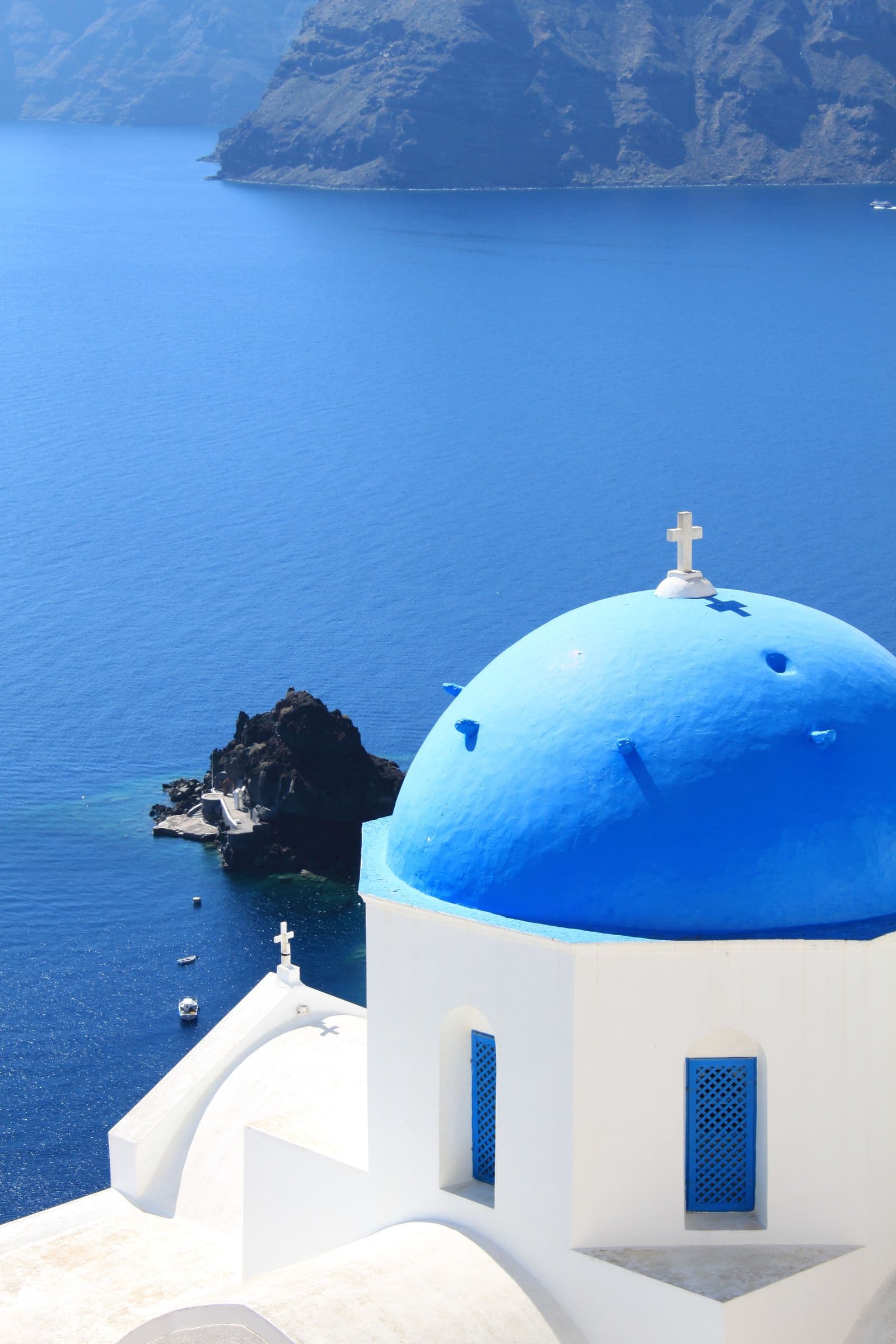Blue domes above whitewashed houses on a Cycladic hillside