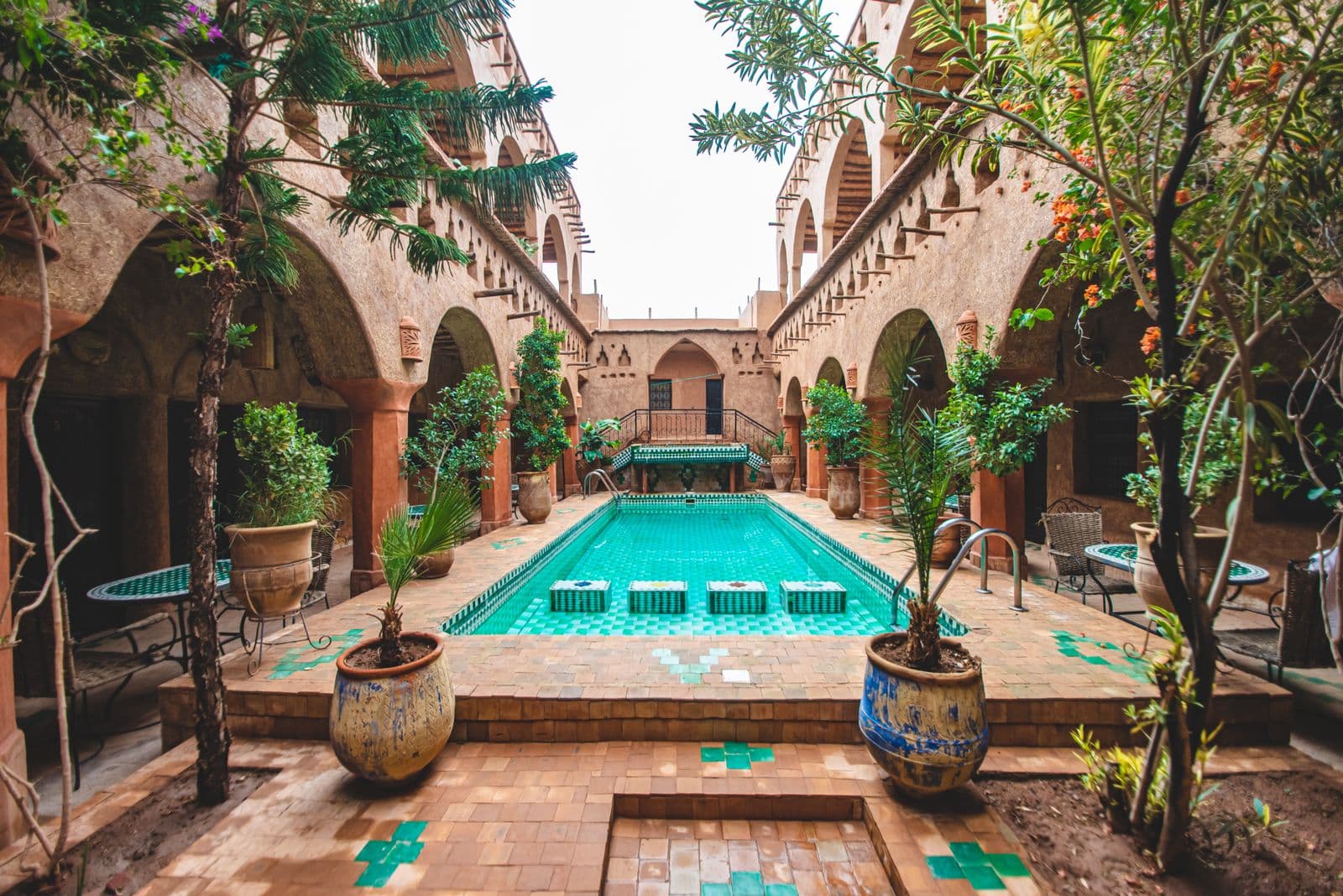 A lantern-lit courtyard with carved arches at dusk
