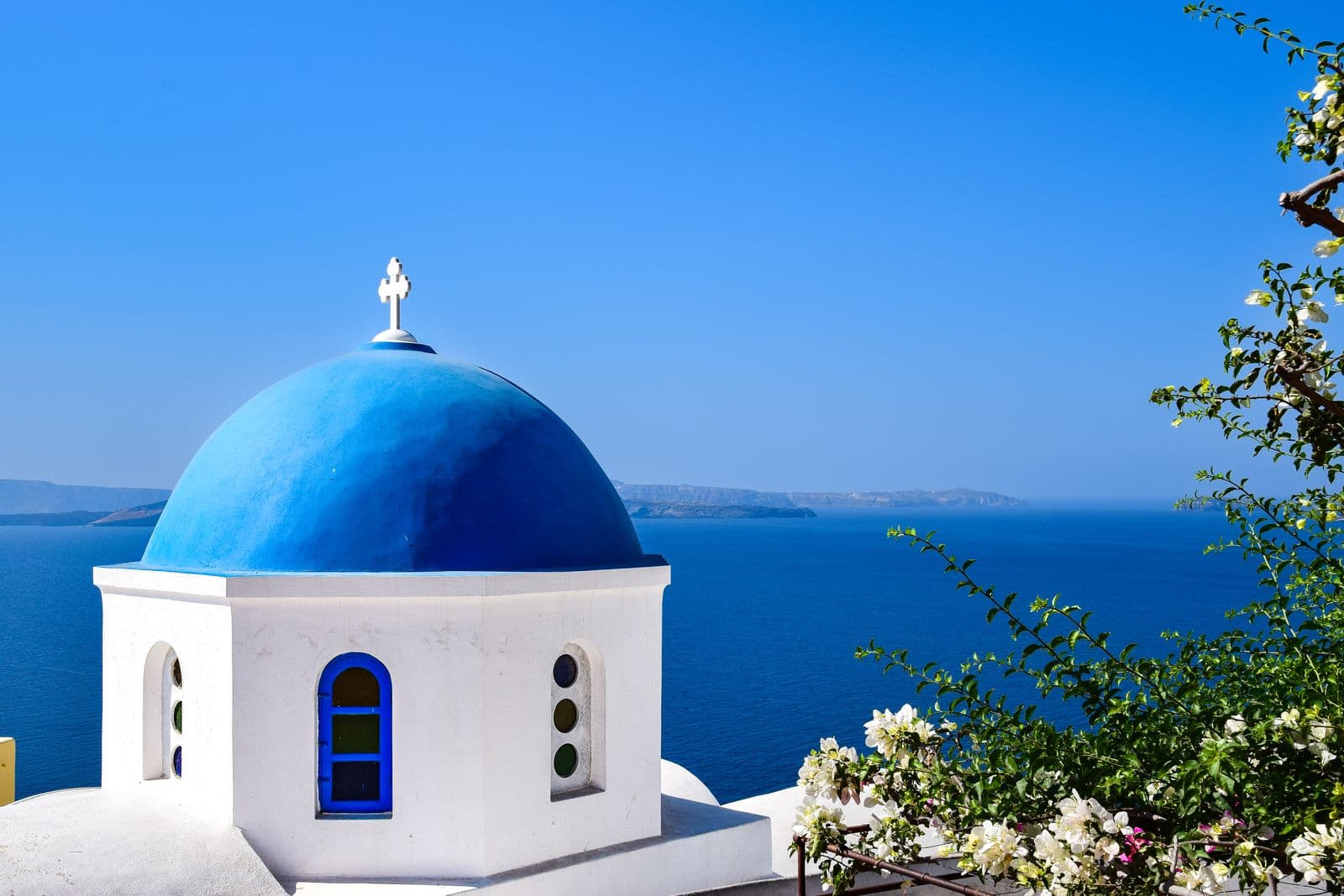 Whitewashed village lanes opening onto a blue dome