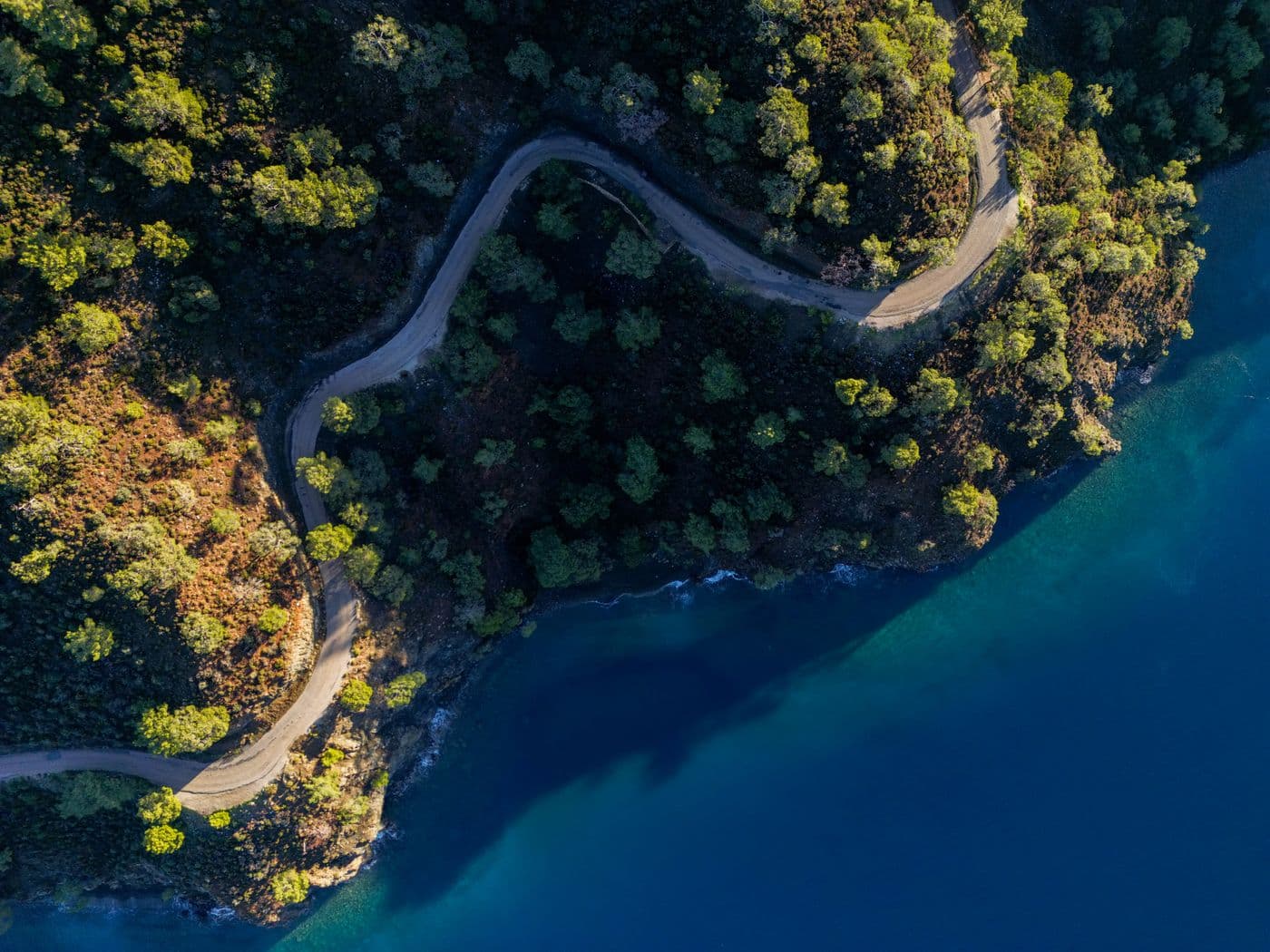 A coastal road threading between headlands